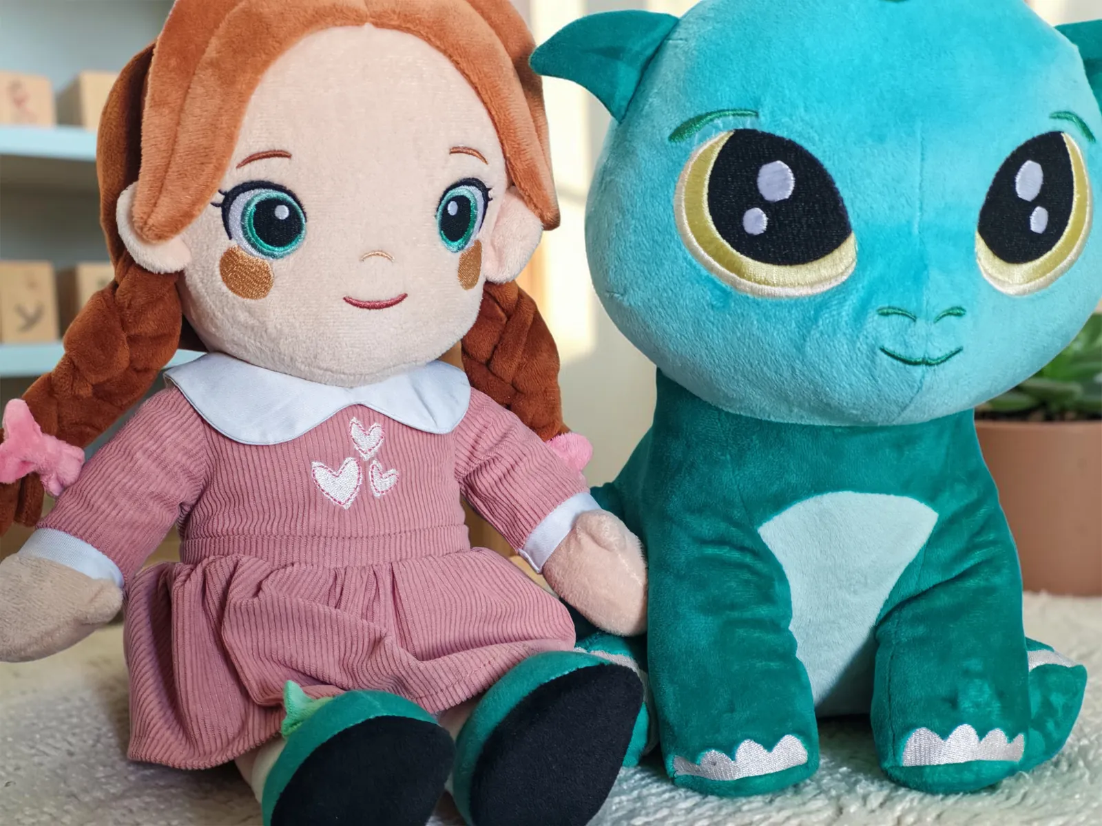 Lotti et Kobi, deux des trois peluches Playnitive, assises côte à côte dans une chambre d’enfant